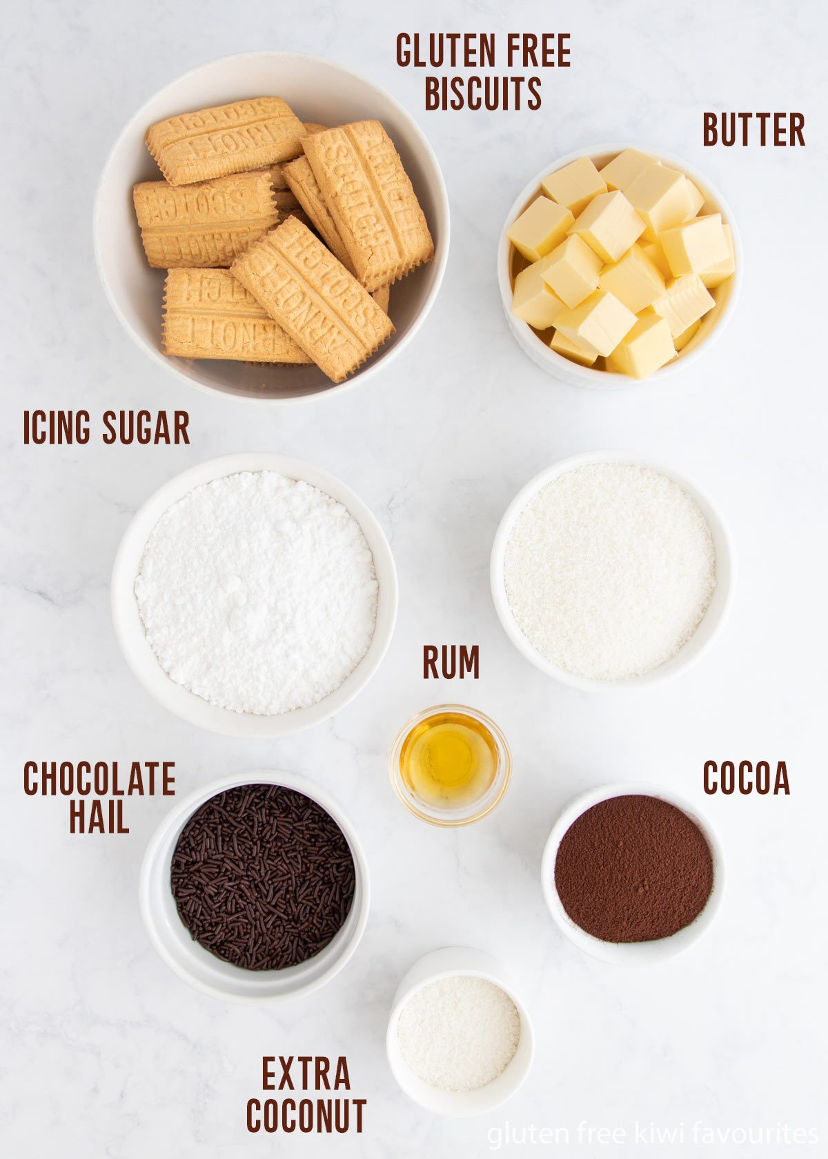 All rum ball ingredients in separate white bowls.