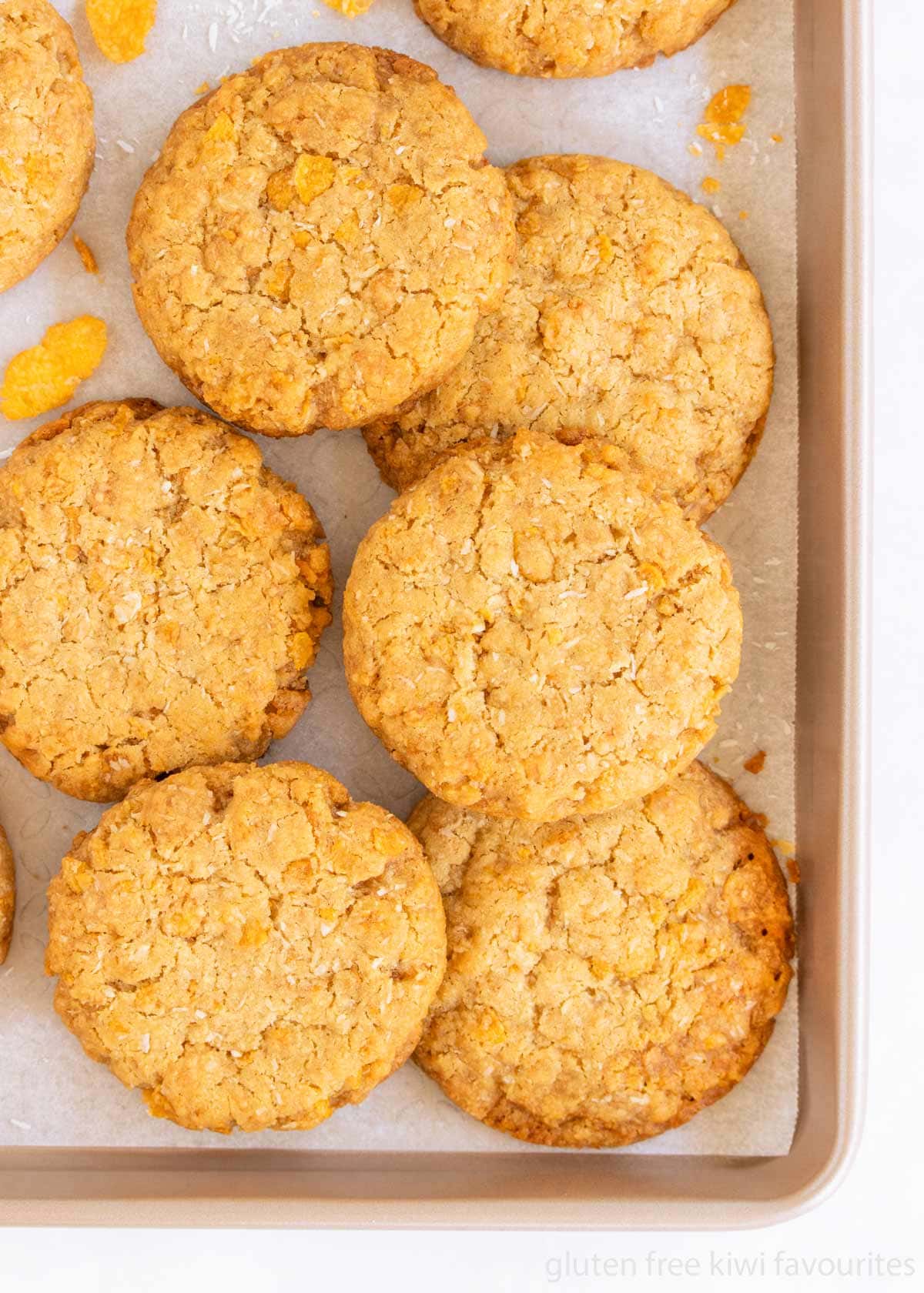Anzac biscuits stacked in a baking tray.