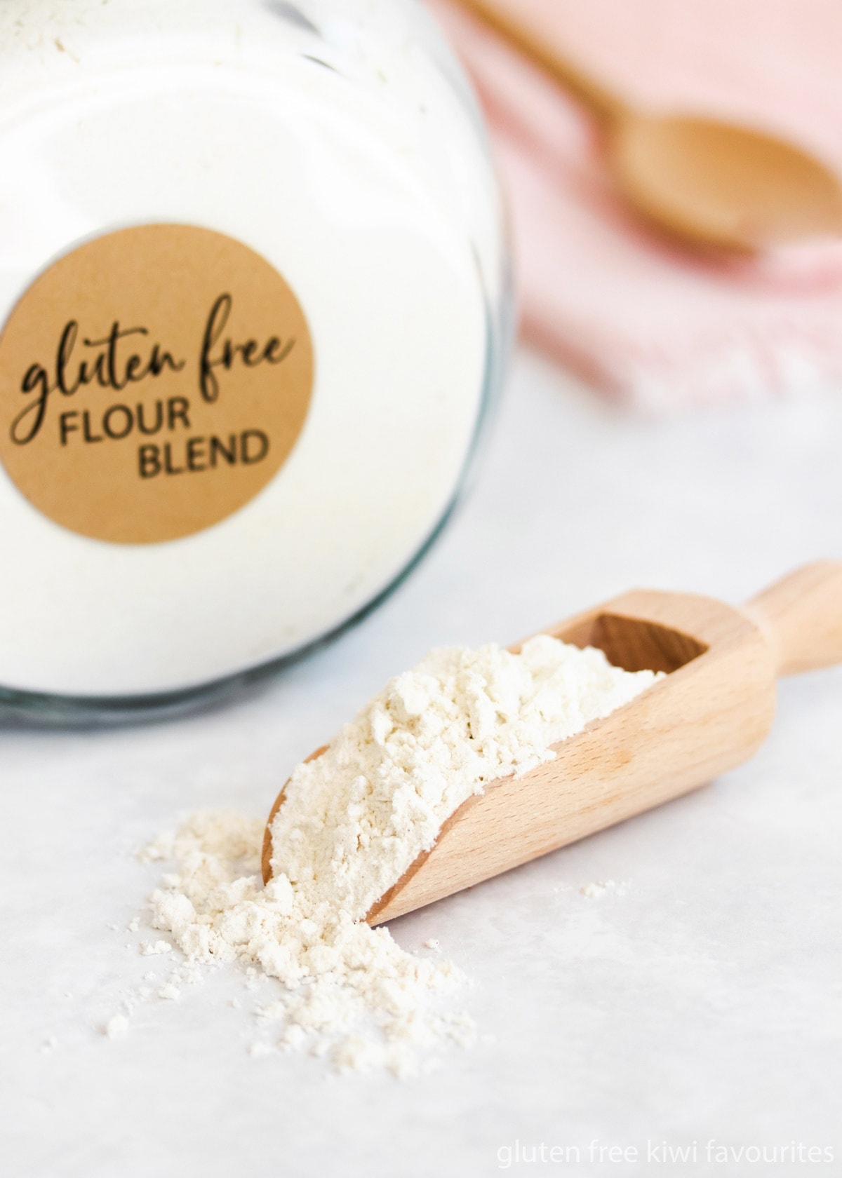 Close up of a wooden scoop full of gluten free flour.