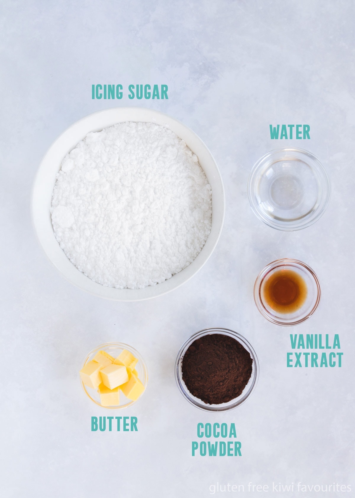 The icing ingredients in bowls on a grey background with text overlay of the ingredient names.