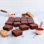 16 squares of gluten free weetbix slice on a grey-blue background.