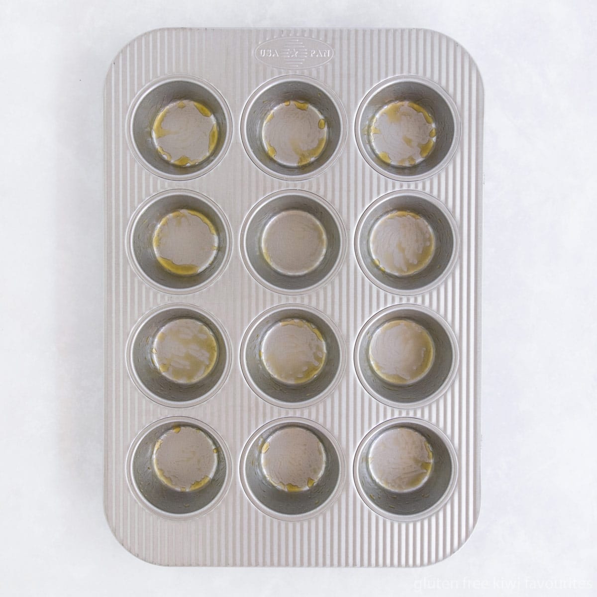 A light metal muffin pan greased with butter.