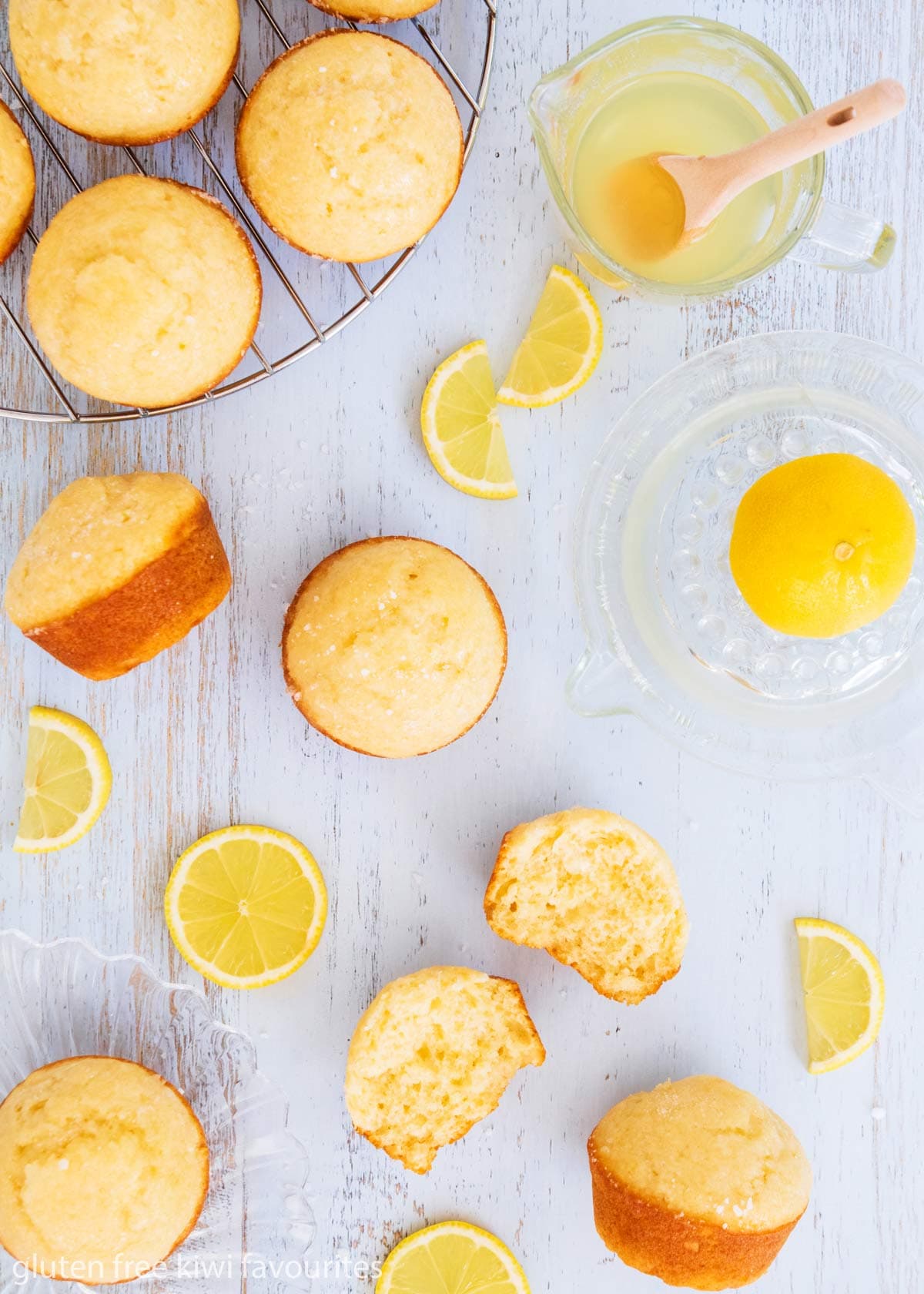 Gluten free crunchy lemon muffins on a blue background with a lemon juicer and lemon slices.