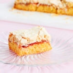 One piece of Louise cake on a spiral rib textured glass plate on a pink background.