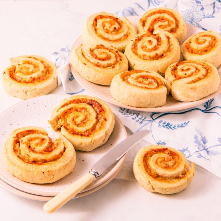 Gluten free pinwheel scones on white plates, with a white linen napkin with blue foliage pattern.