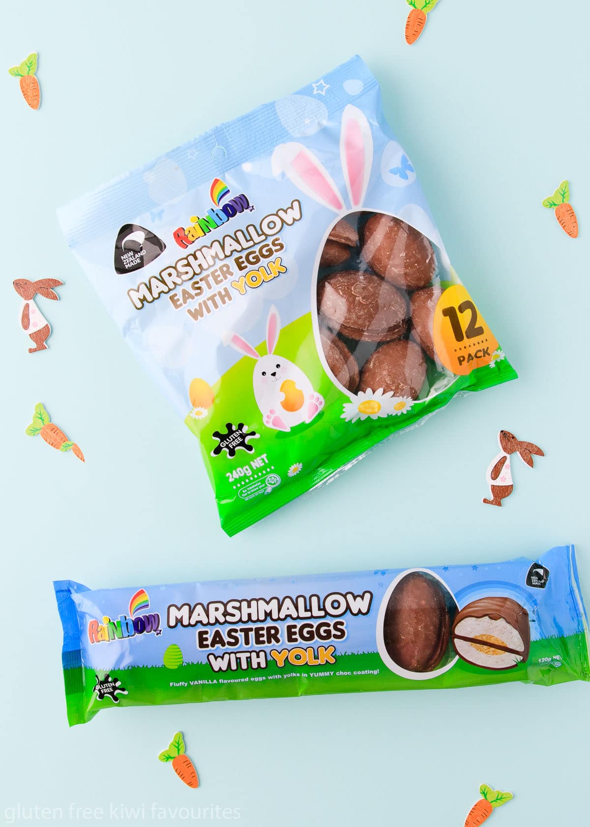 Rainbow gluten free easter eggs, on a mint green background with little wooden bunnies and carrots.