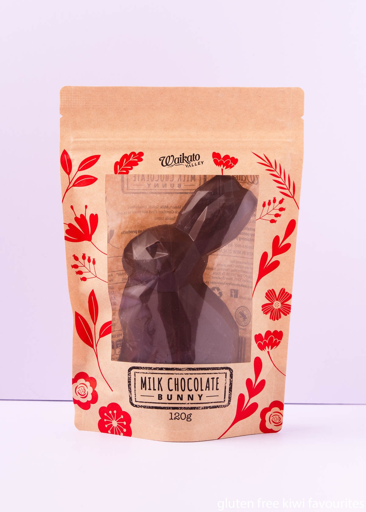 A Waikato Valley milk chocolate bunny in packaging that is brown with red floral pattern, and a clear window showing the bunny. 