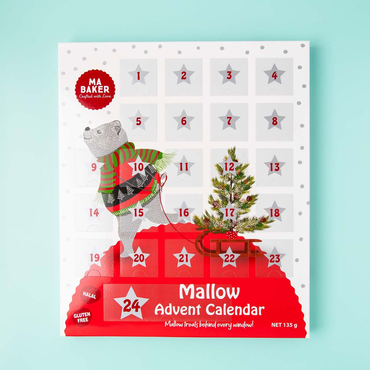 A Ma Baker marshmallow advent calendar, that has a picture of a bear wearing a Christmas jumper and a scarf, pulling a Christmas tree on a sled.