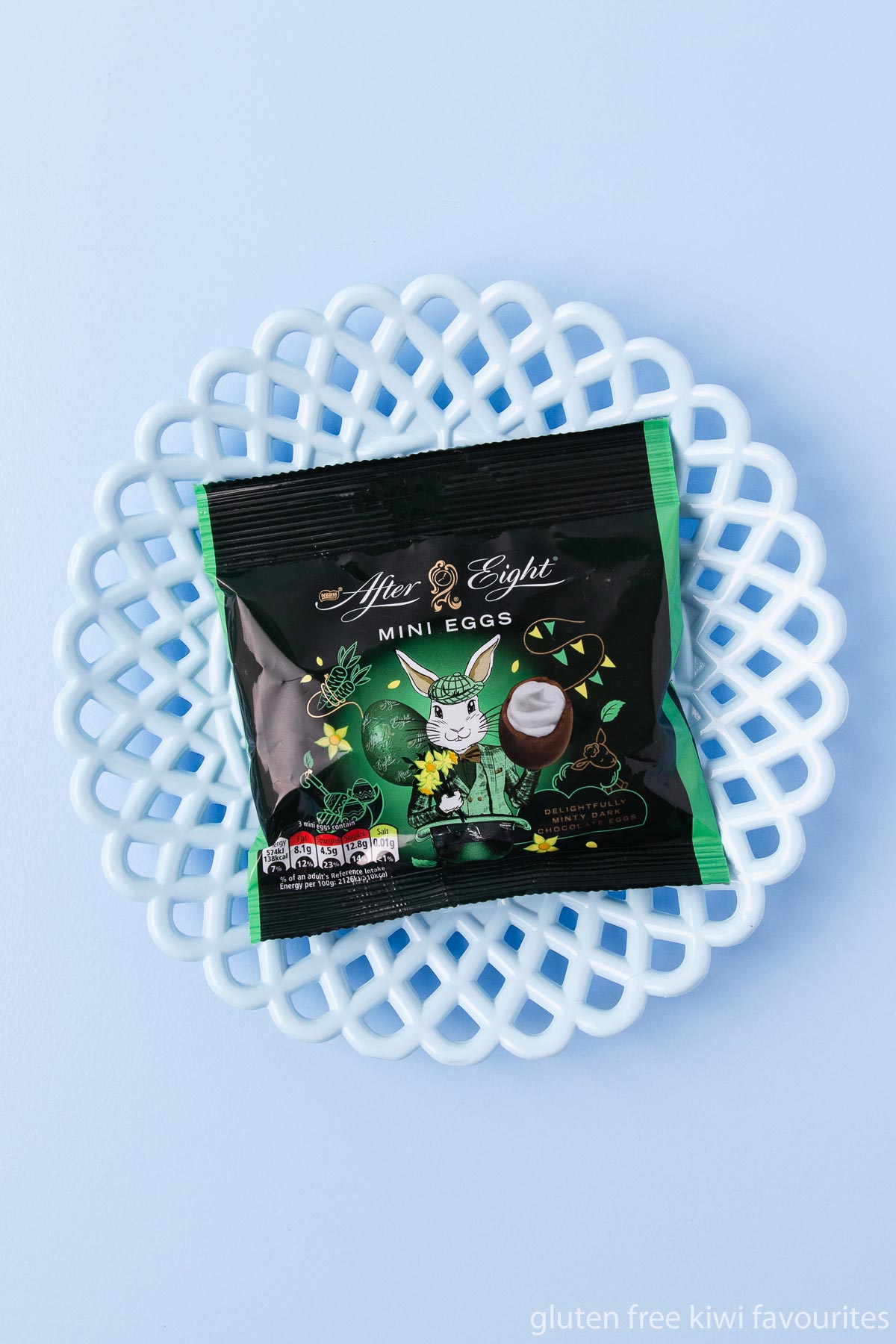 A bag of After Eight brand dark chocolate mini eggs on a blue background.