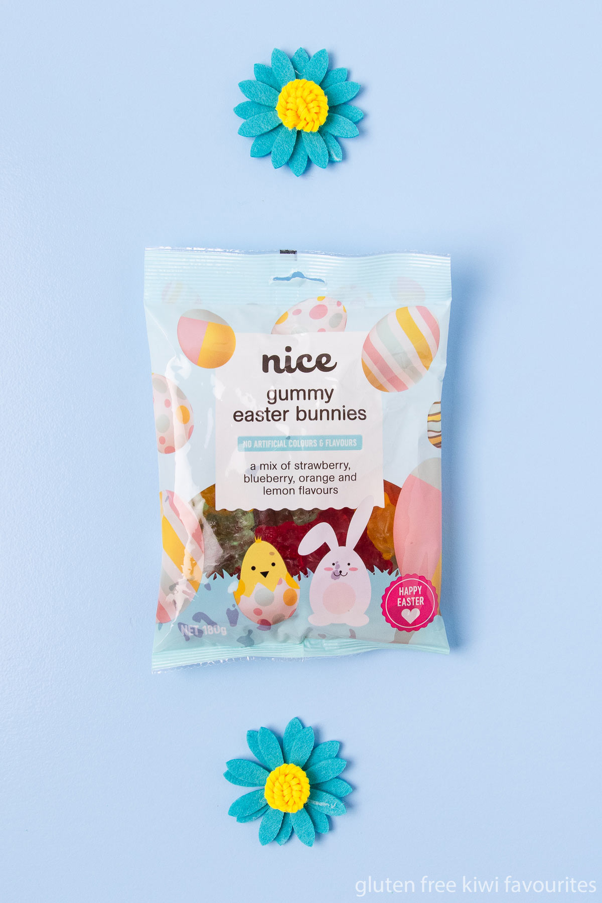 A bag of Nice brand gummy Easter bunny lollies on a blue background.