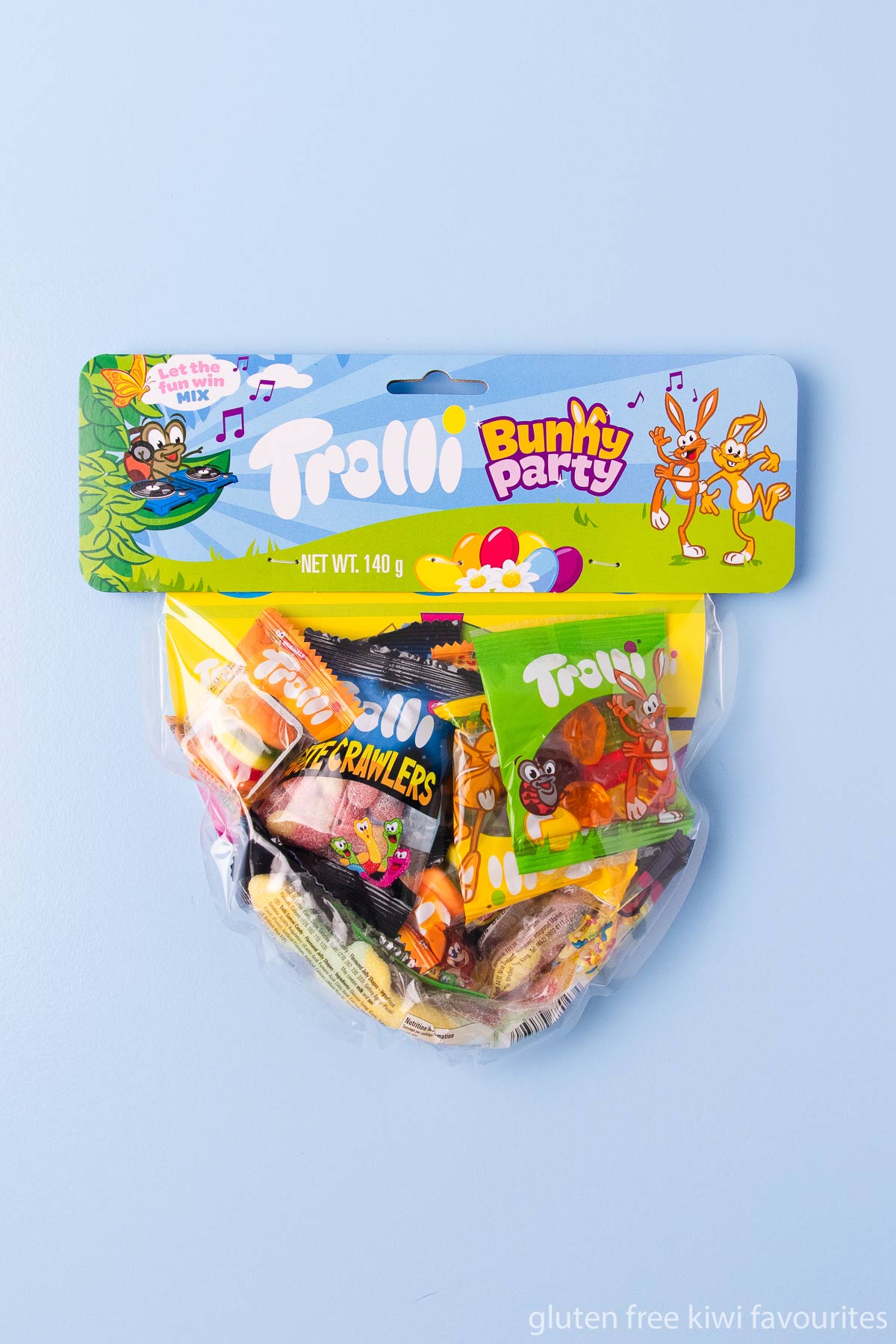 A bag of Trolli brand "bunny party" gummy lollies on a blue background.