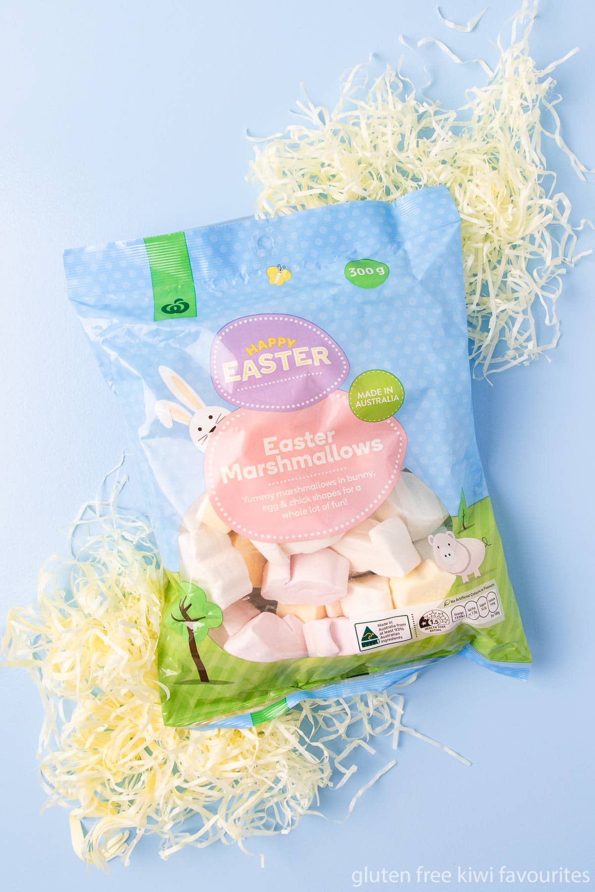 A bag of Woolworths brand Easter marshmallows on a blue background.
