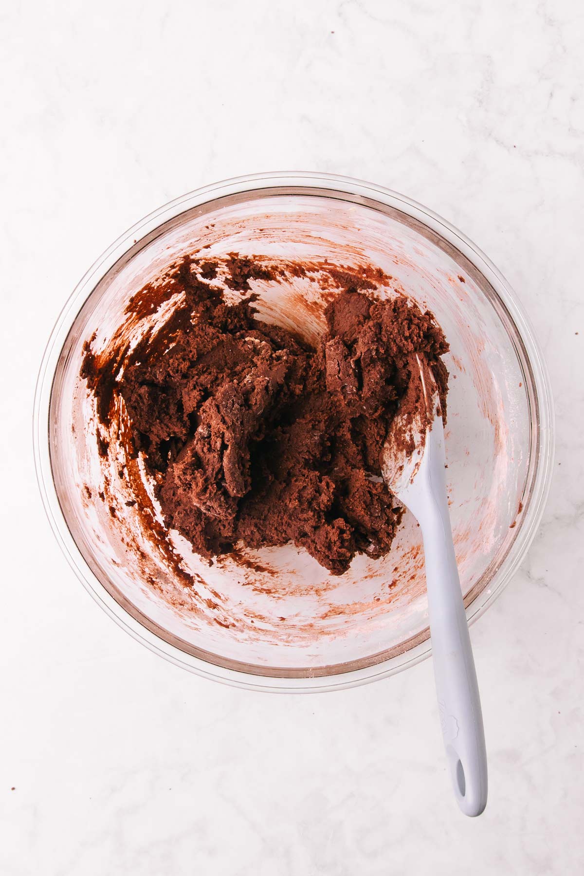 The chocolate biscuit dough after being mixed with a silicone spoon.
