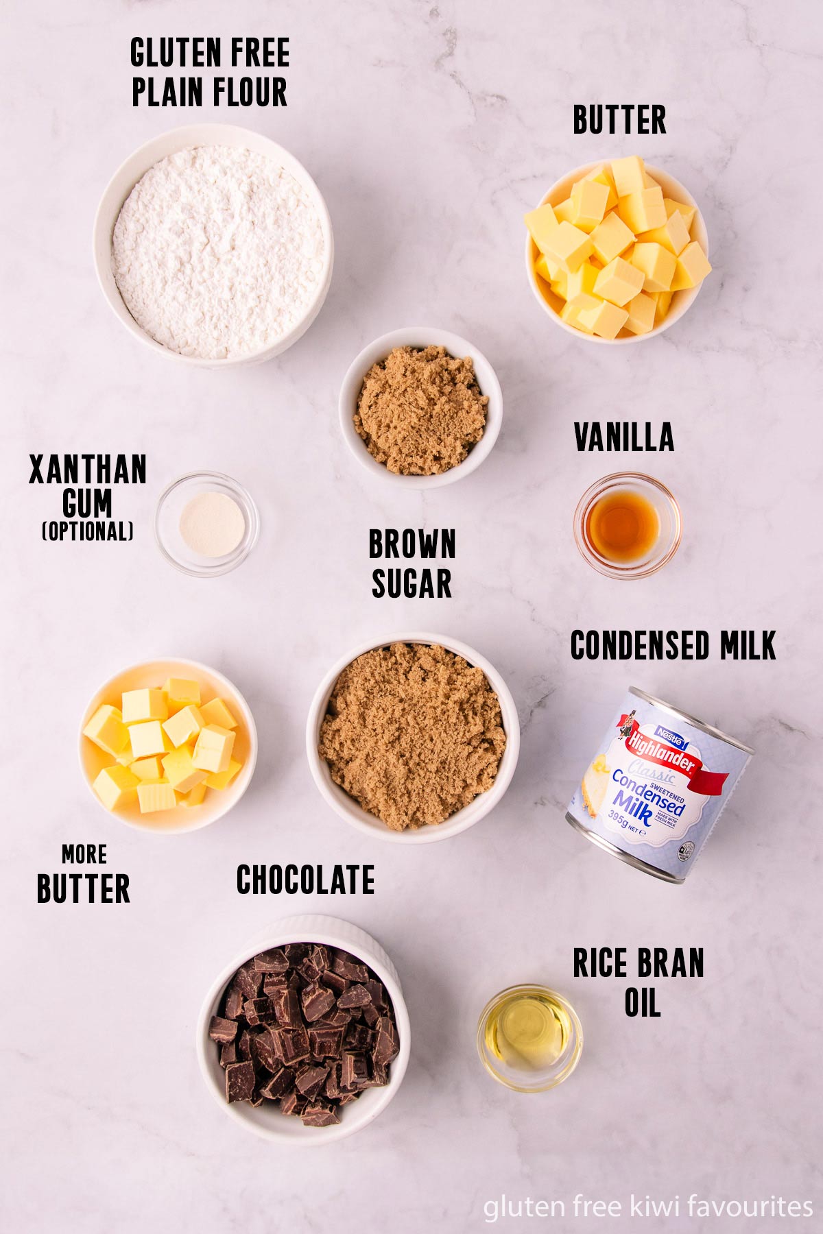 The gluten free caramel slice ingredients laid out in white bowls on a grey marble background.