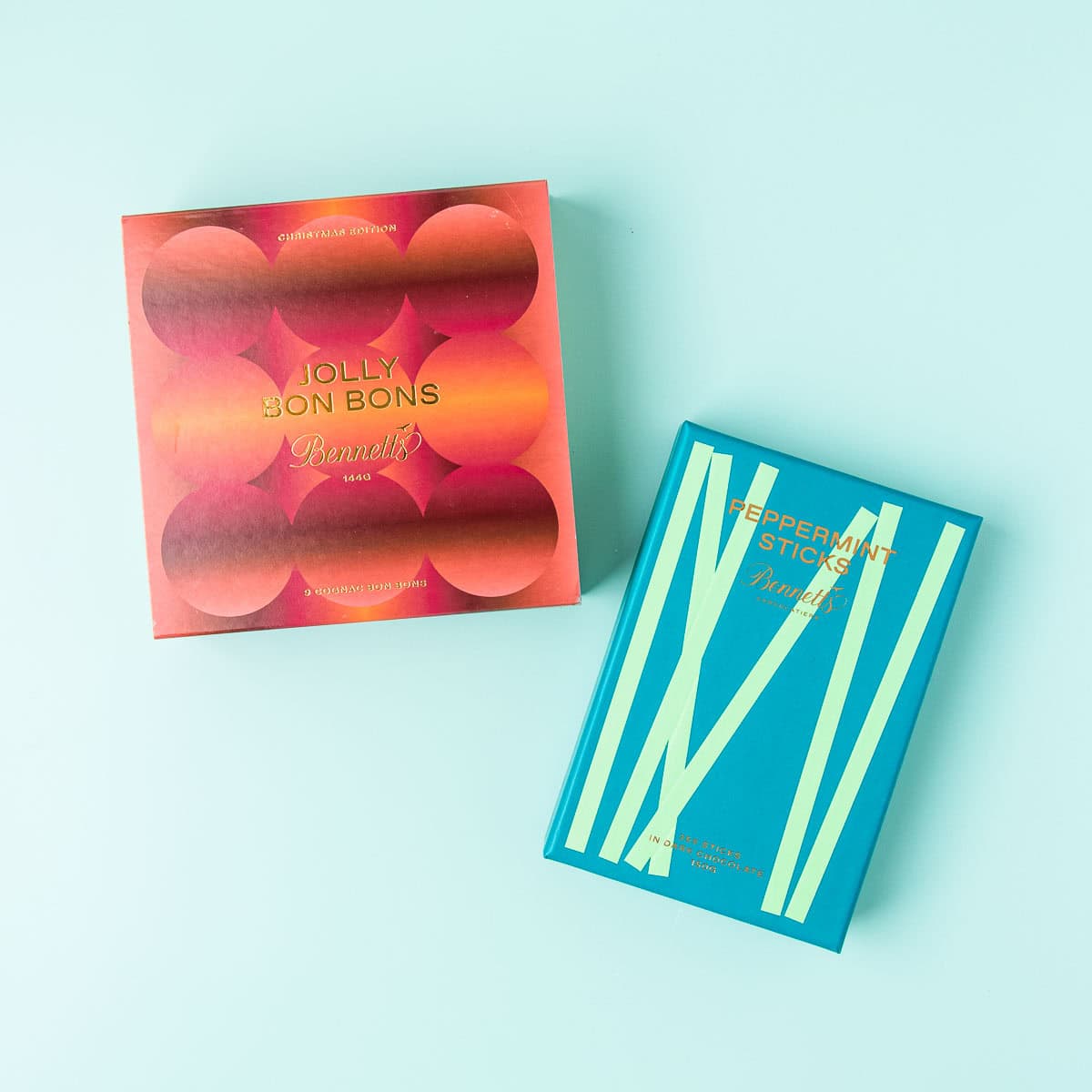 A box of Bennetts Jolly Bon Bons and Peppermint Sticks, on a mint green background.