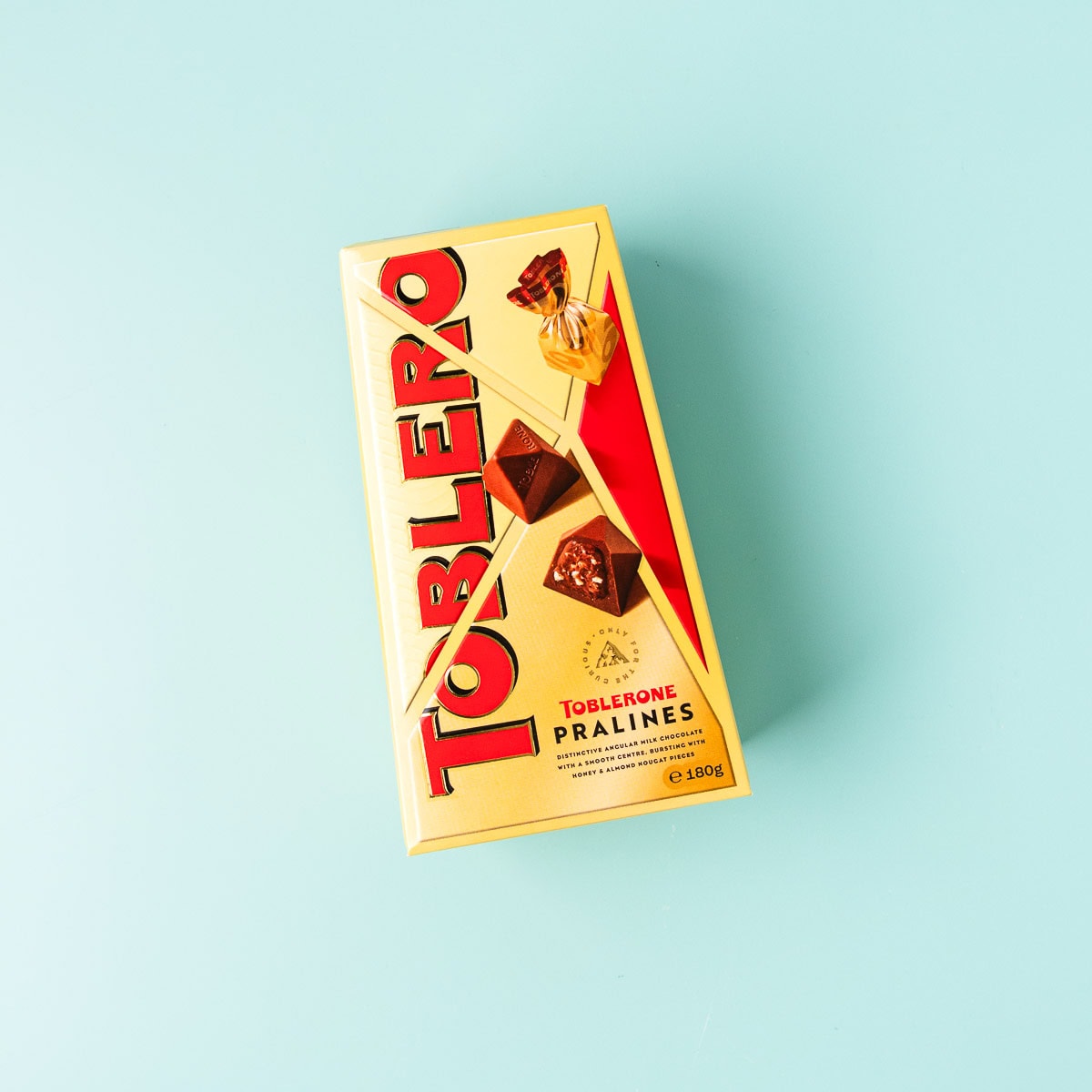 A box of Toblerone praline chocolates on a mint green background.
