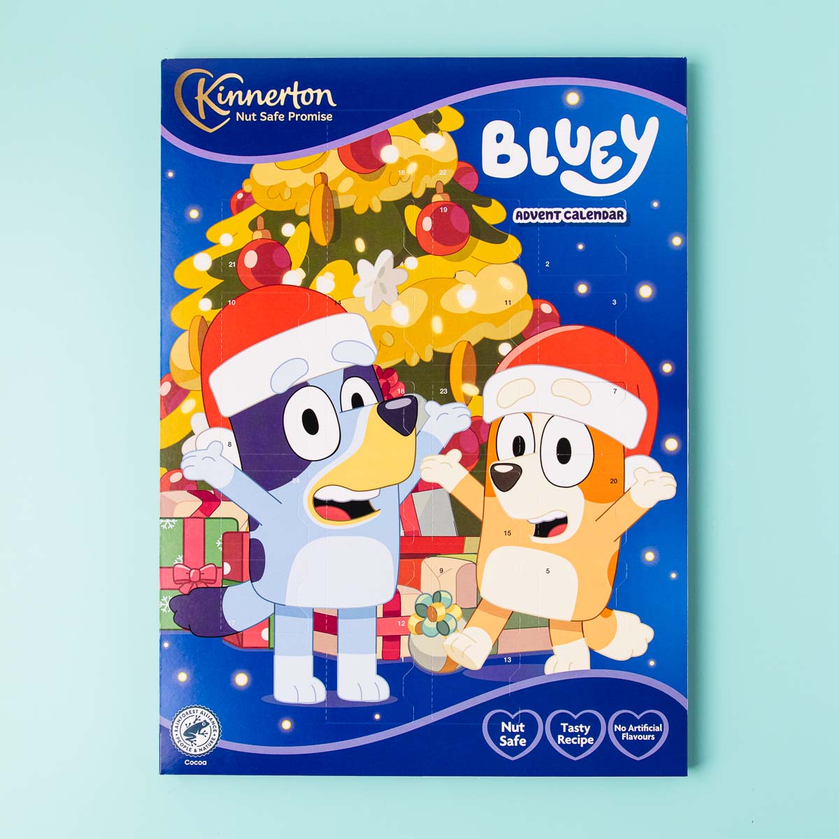 A Kinnerton brand advent calendar. The calendar has a picture of Bluey and Bingo standing in front of a Christmas tree.