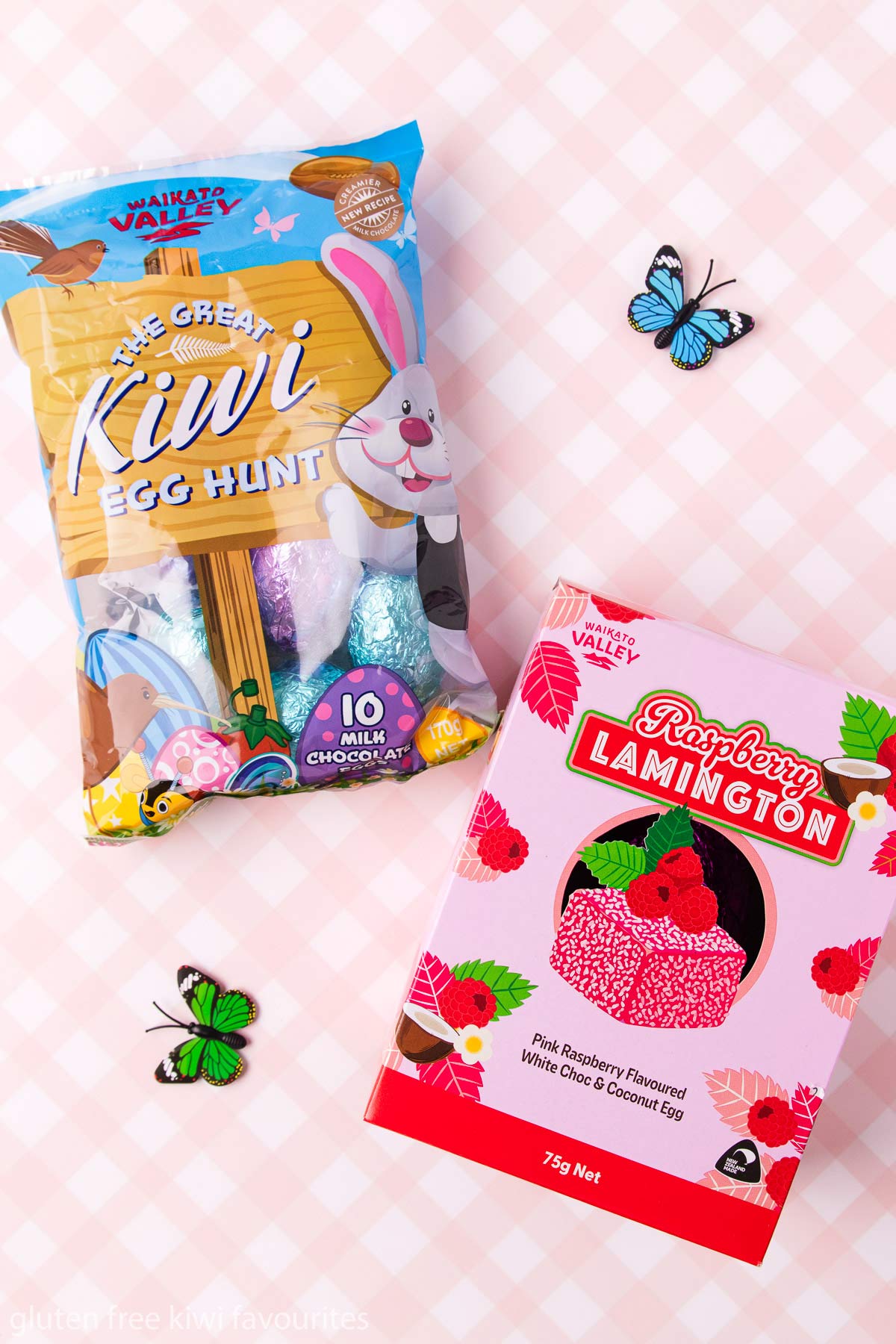 A bag of Waikato Valley egg hunt eggs and raspberry lamington Easter egg, on a pink and white checked background.